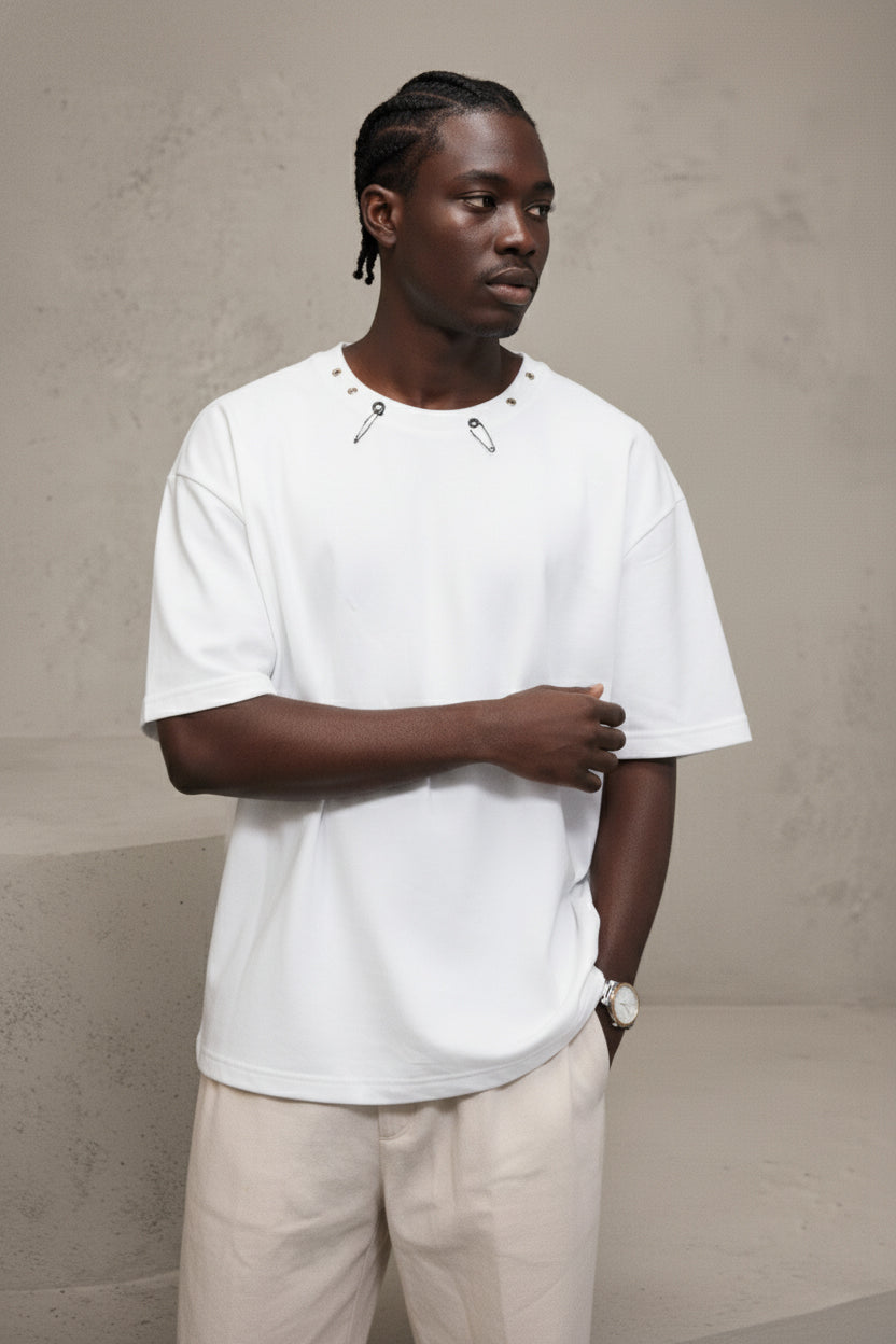 Man wearing a white t-shirt and beige pants against a plain background