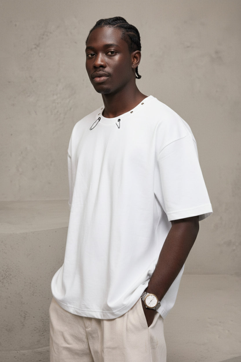 Man wearing a white t-shirt and beige pants against a plain background