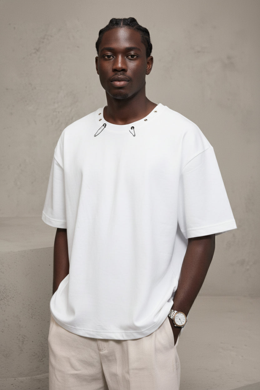 Man wearing a white t-shirt and beige pants against a plain background