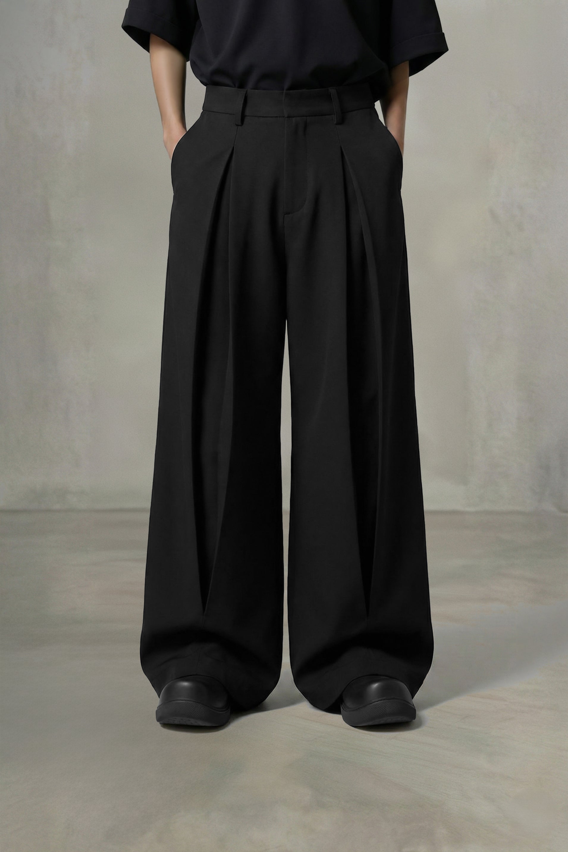 Person wearing black wide-leg pants and a black shirt against a plain background