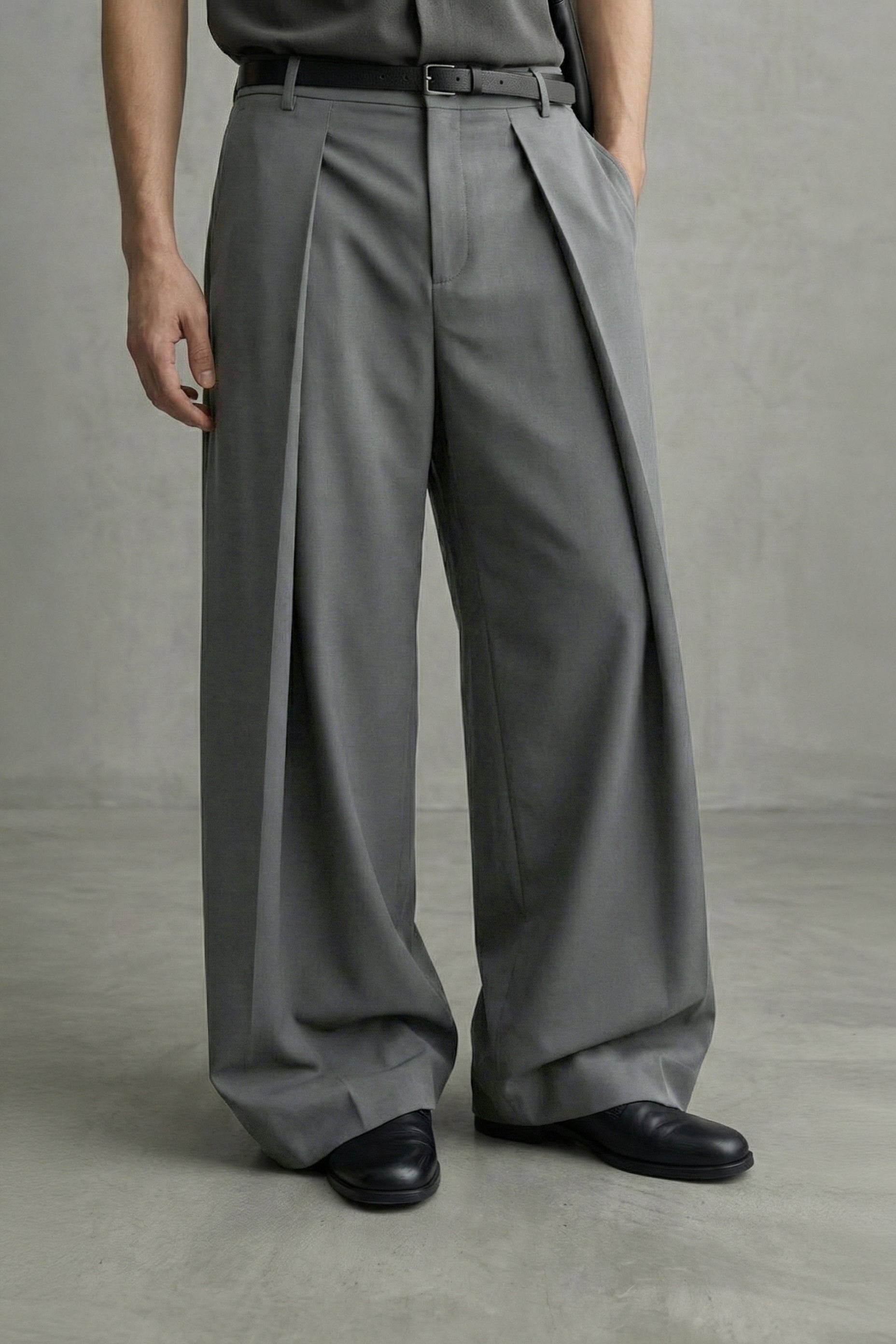 Person wearing gray wide-leg pants against a plain background