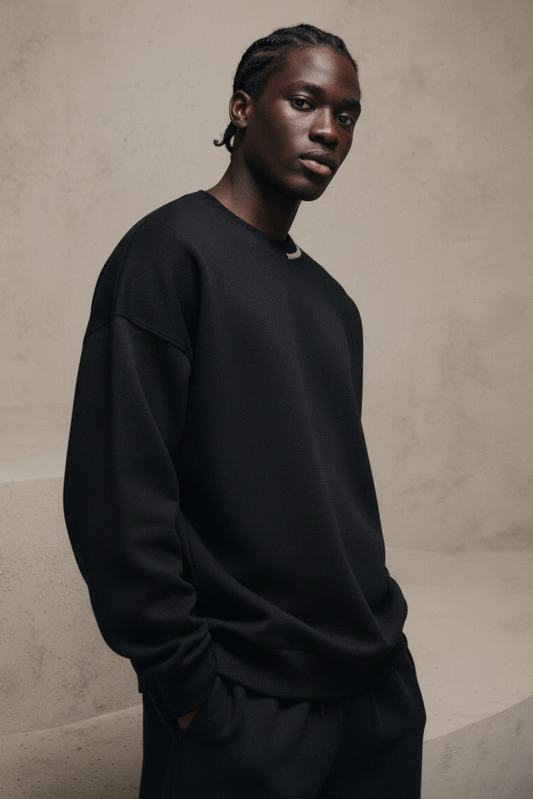 Person wearing a black sweatshirt against a beige background