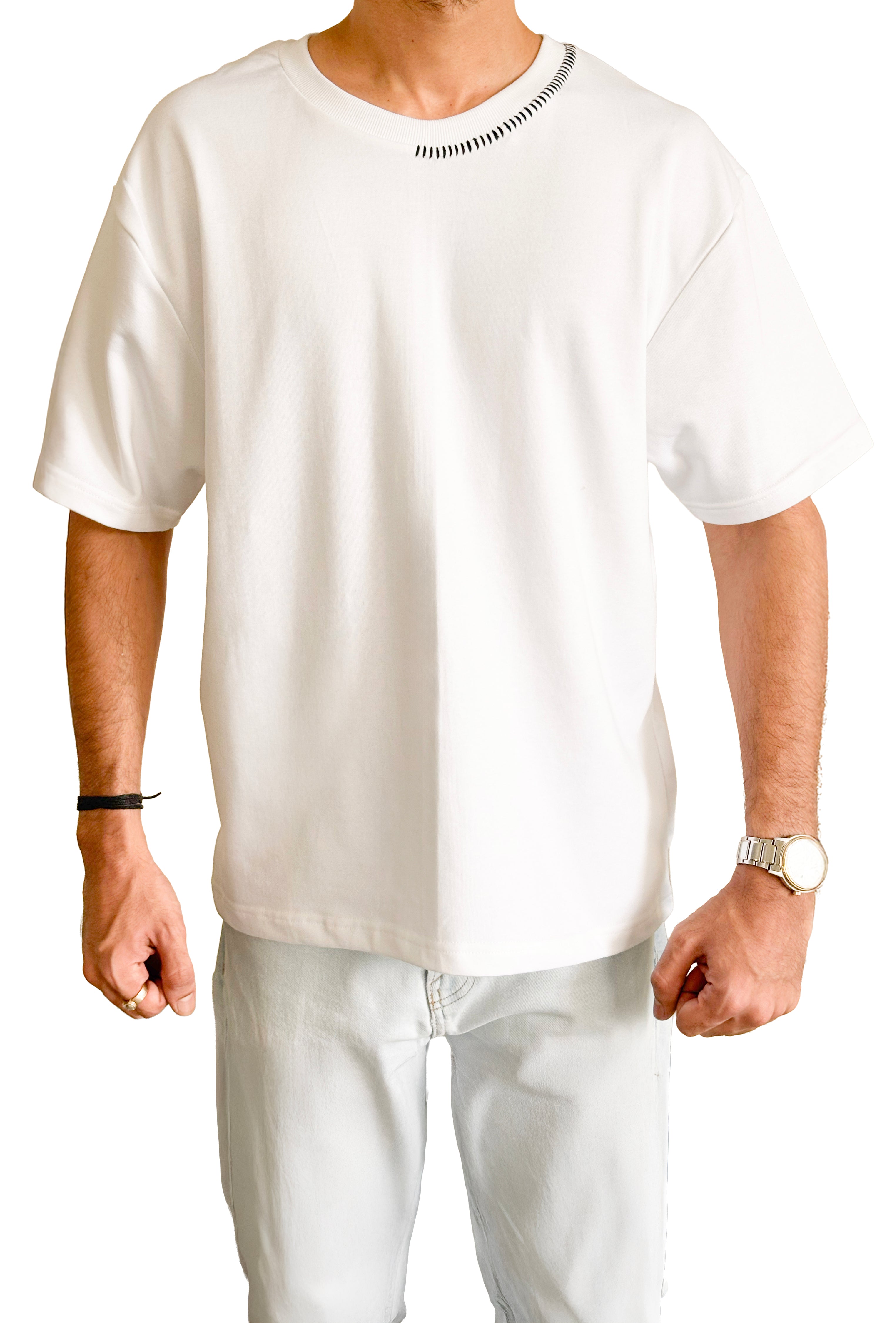 Man wearing a plain white t-shirt and light-colored pants on a white background