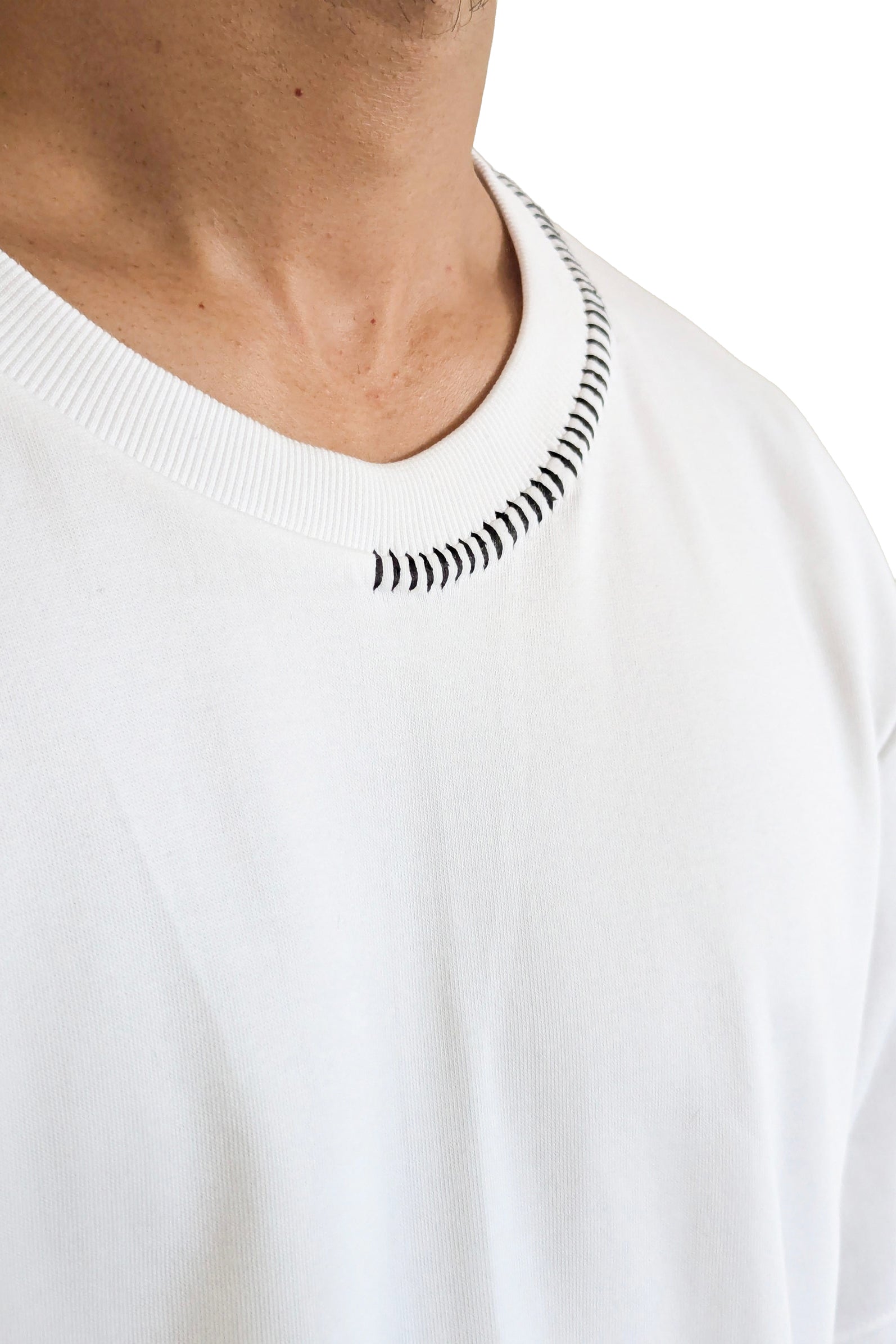 White sweater with black patterned neckline on a white background