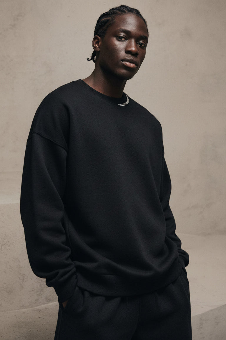 Person wearing a black sweatshirt against a beige background