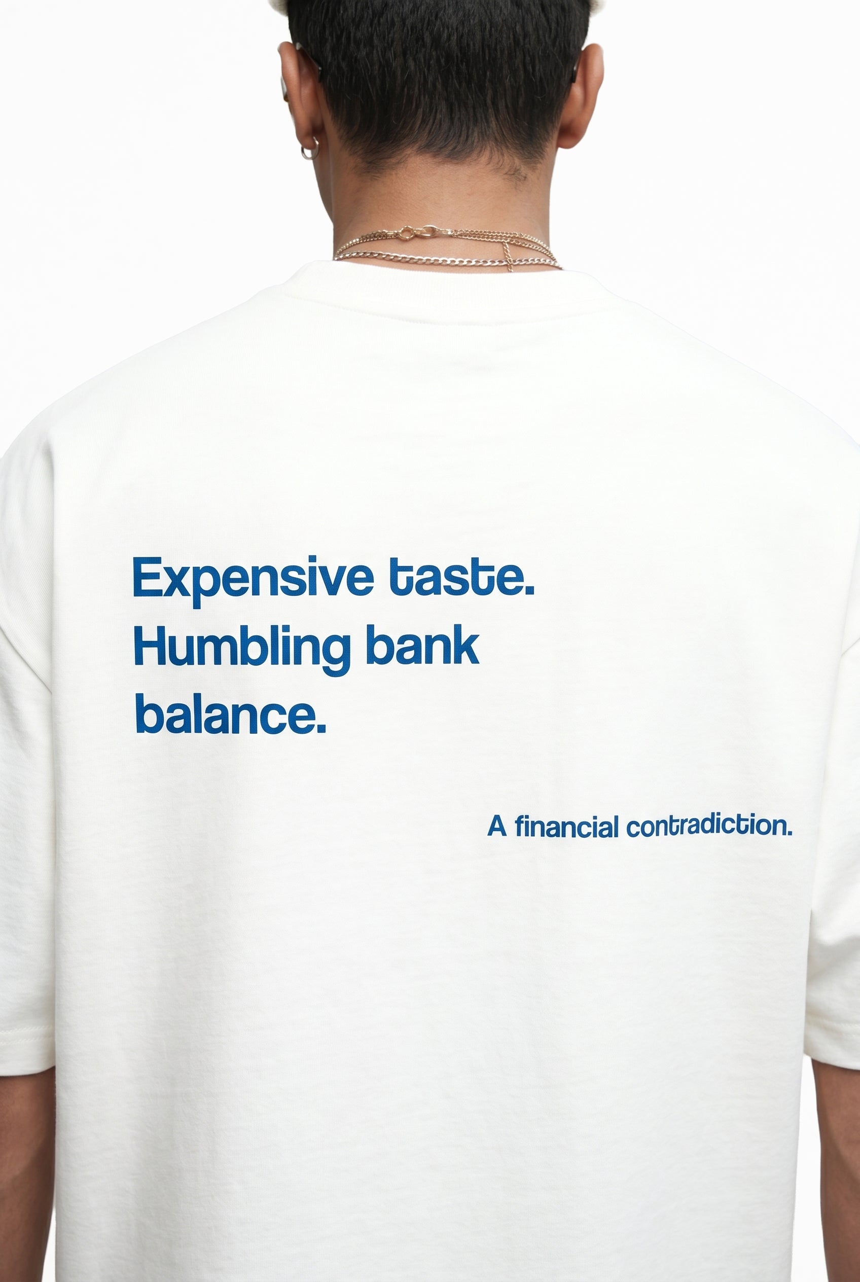 Person wearing a white t-shirt with blue text on the back.