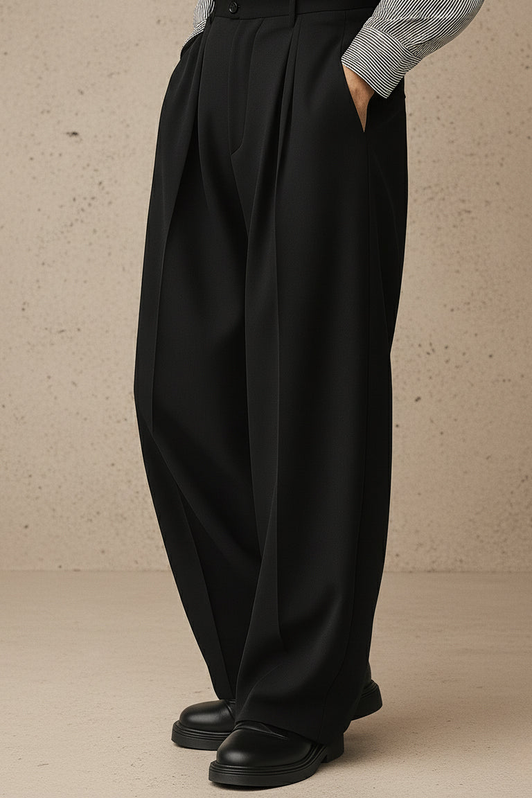 Person wearing black wide-leg pants with a plain background
