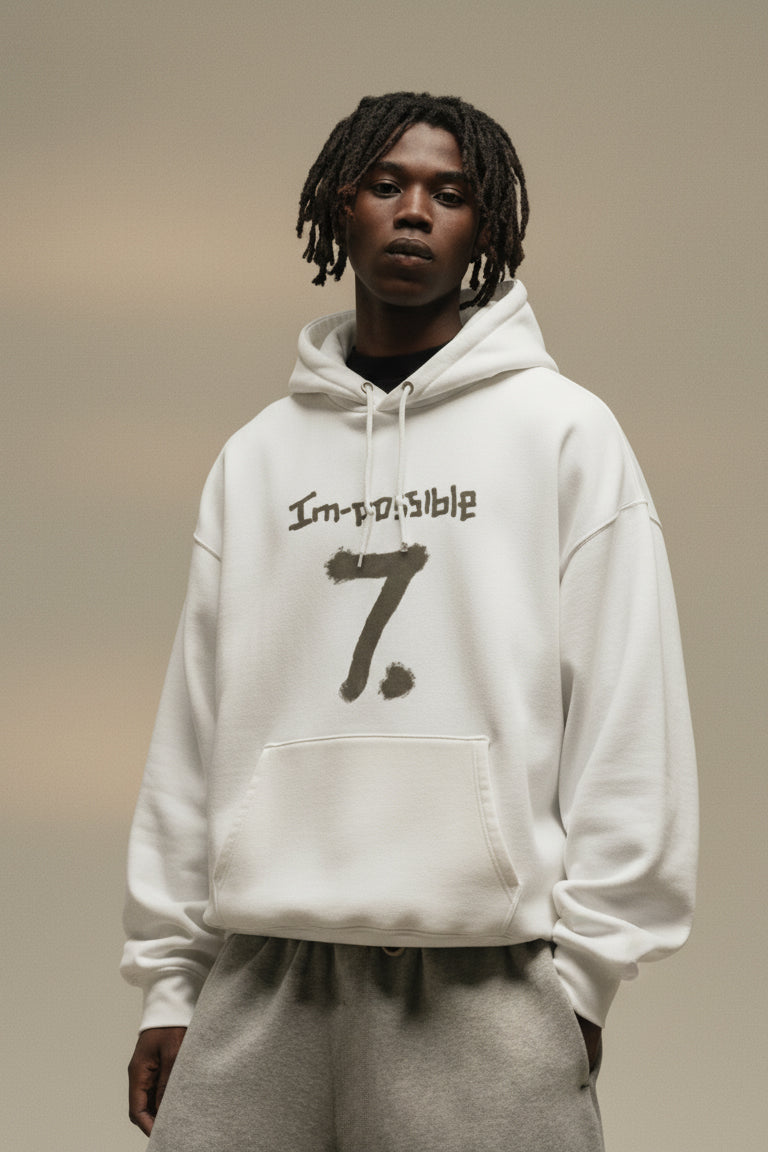 Person wearing a white hoodie with text and number design on a neutral background