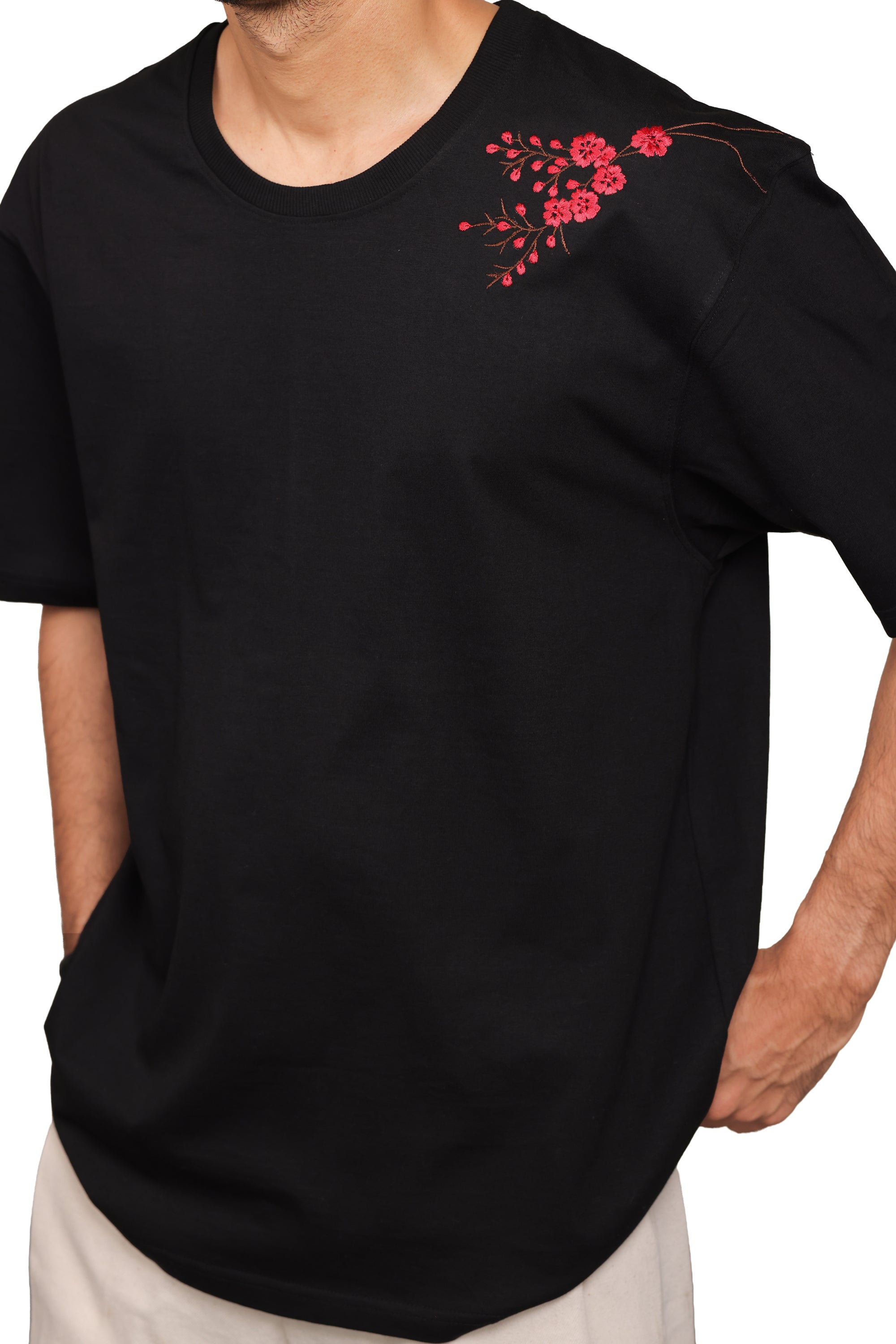 Black t-shirt with red floral embroidery on a white background