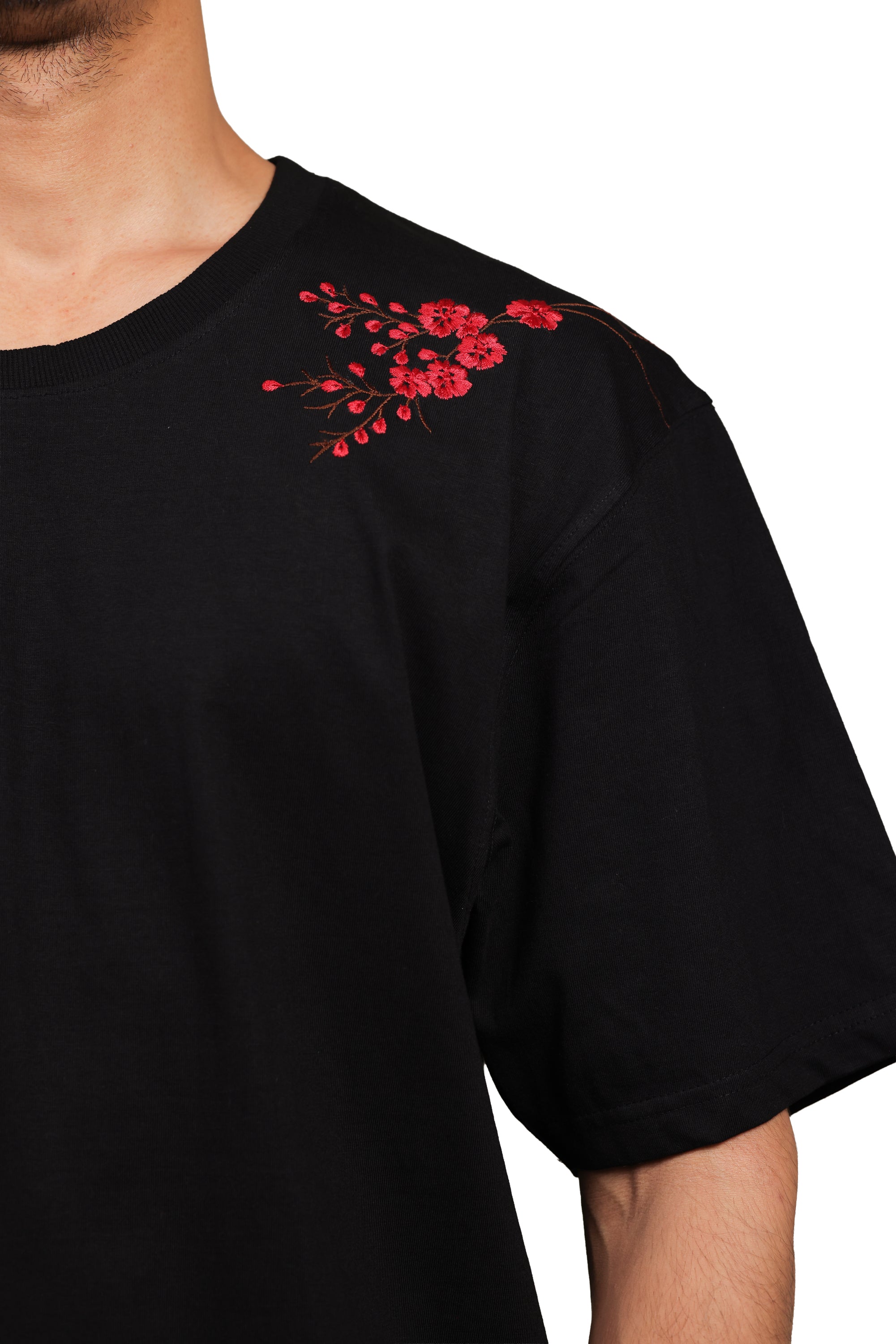 Black t-shirt with red floral embroidery on a white background