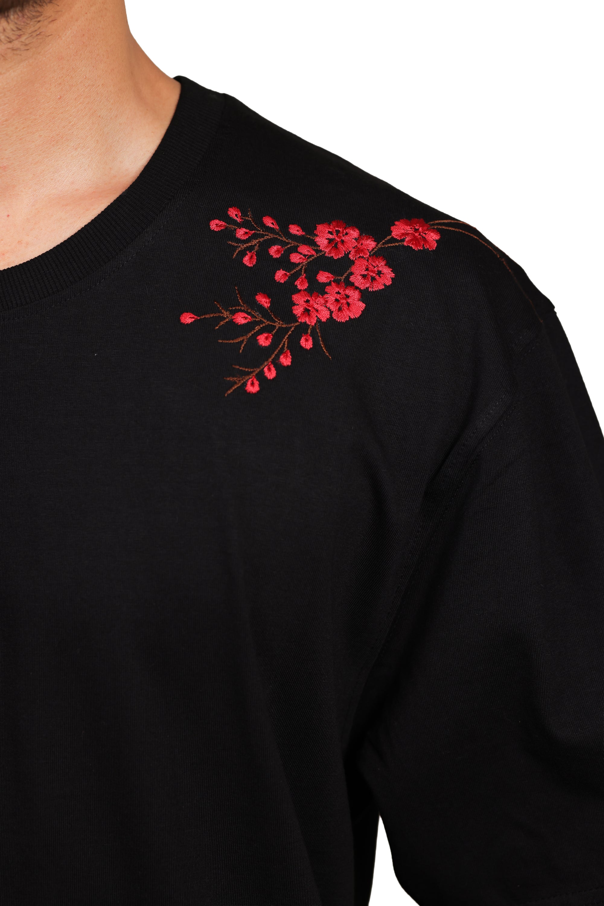 Black shirt with red floral embroidery on a white background