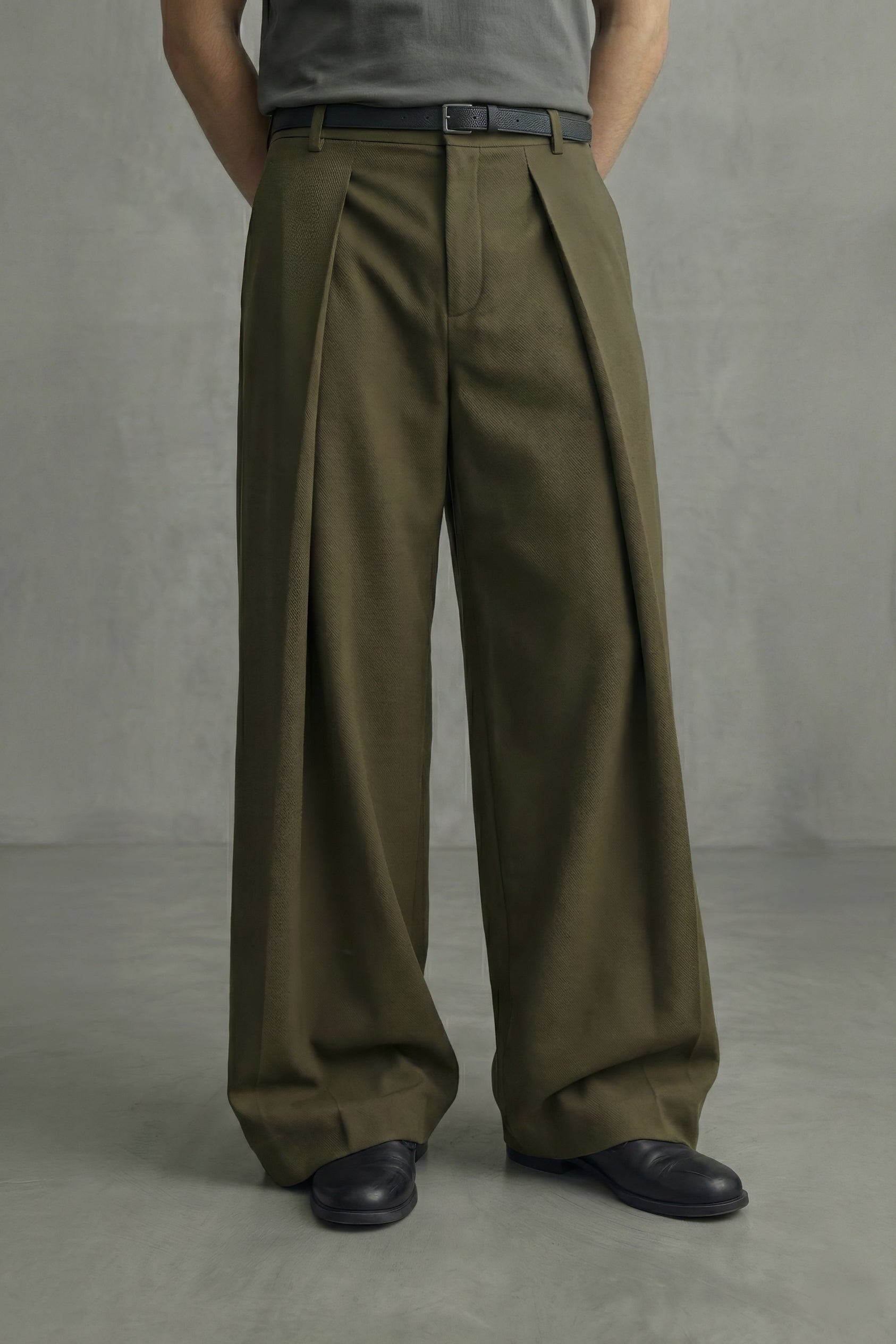 Person wearing olive green wide-leg pants against a gray background