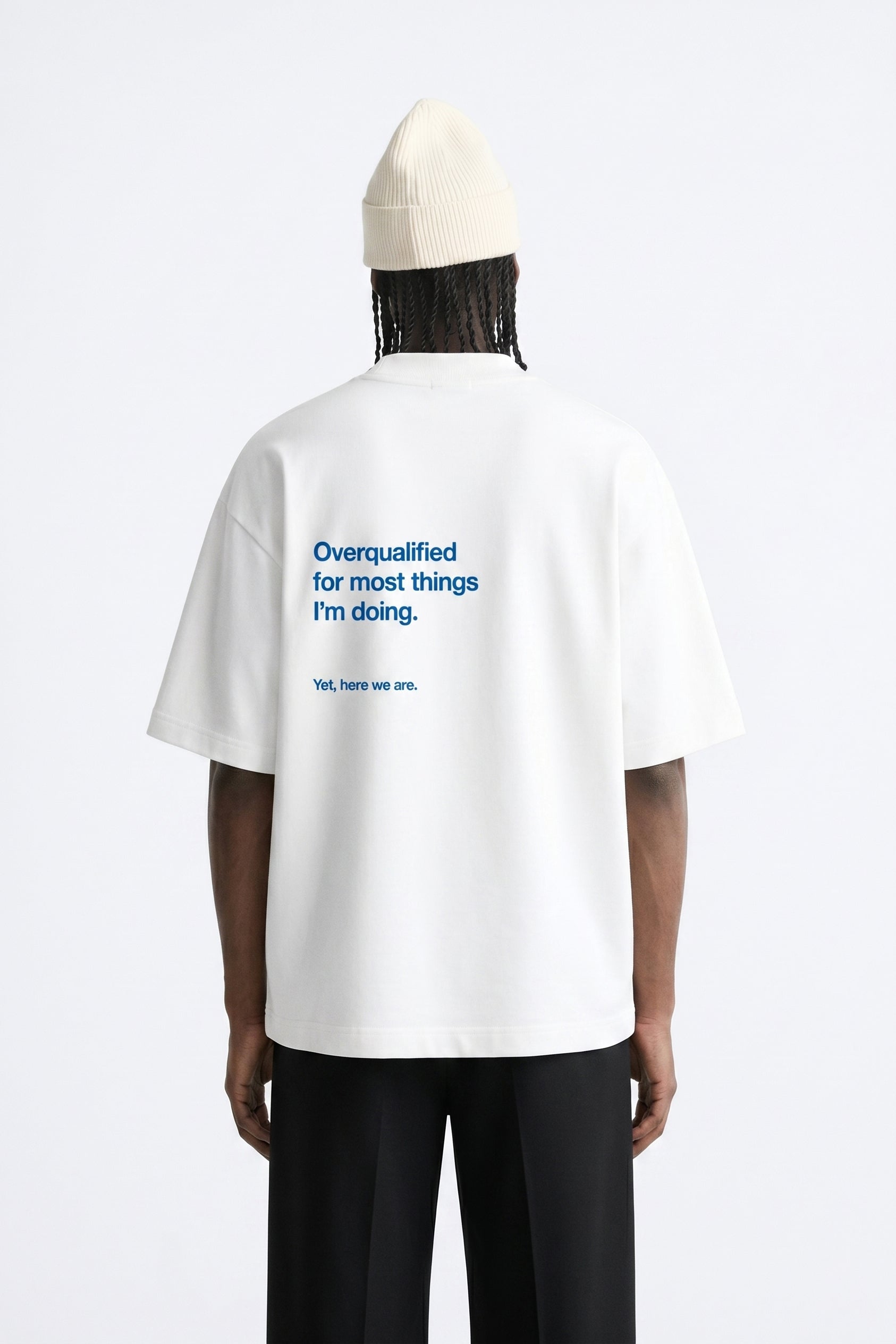 Person wearing a white t-shirt with text on the back, standing against a white background