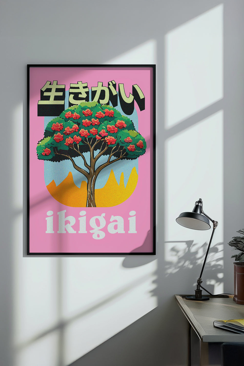 Poster with a tree and 'ikigai' text on a pink background in a room with a desk and lamp.