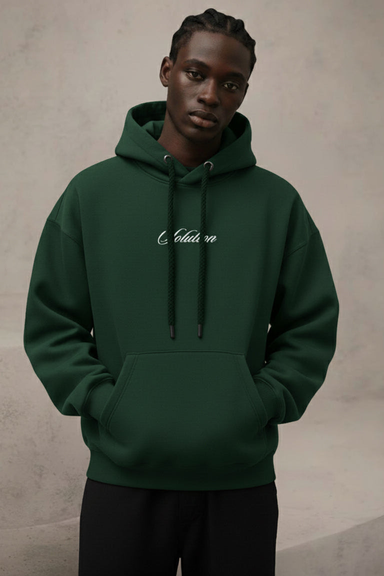 Person wearing a green hoodie with text on a neutral background