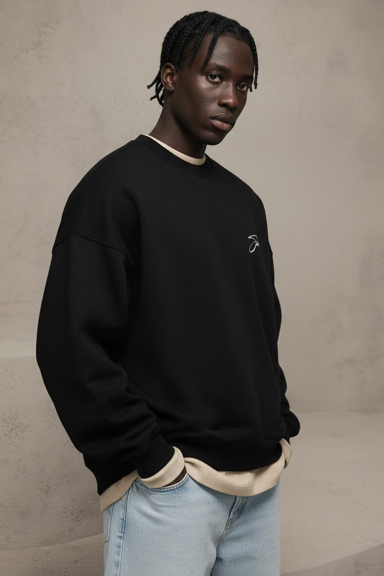 Man wearing a black sweatshirt with a logo against a beige background