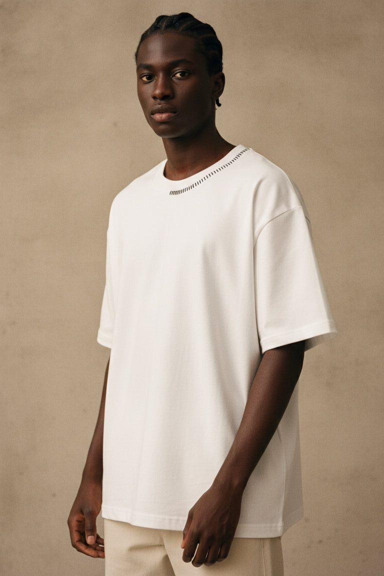Man wearing a white t-shirt against a beige background