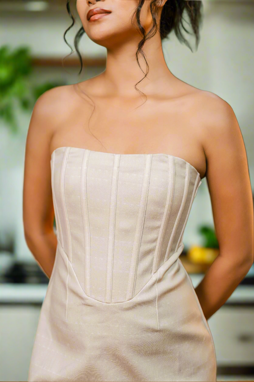 Woman wearing a beige strapless dress in a kitchen setting