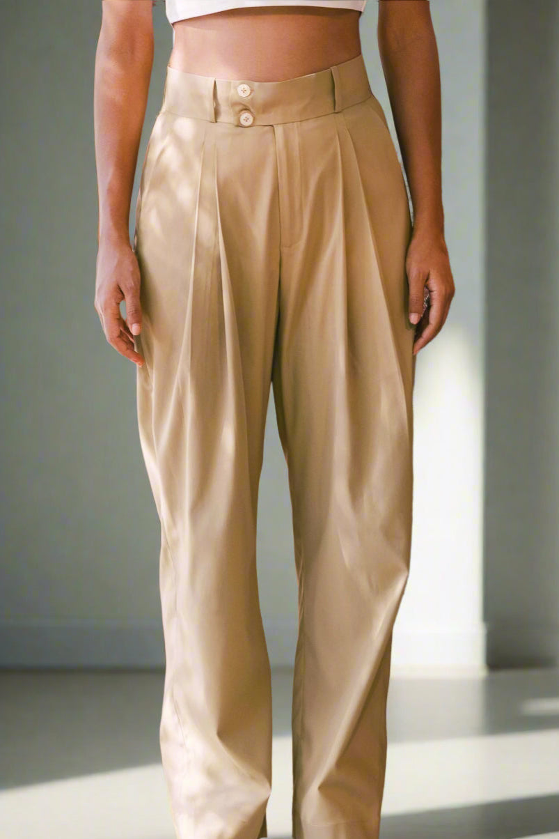 Person wearing beige pants standing in front of a colorful background
