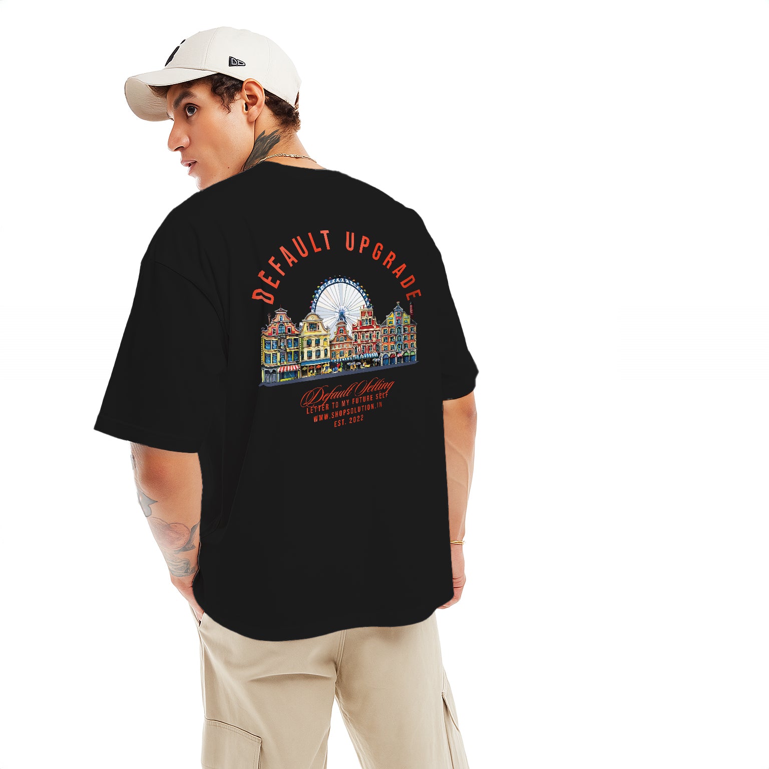 Person wearing a black t-shirt with a colorful graphic and text on the back, standing against a white background.