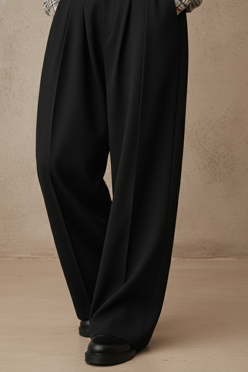 Black wide-leg pants worn by a person on a beige background