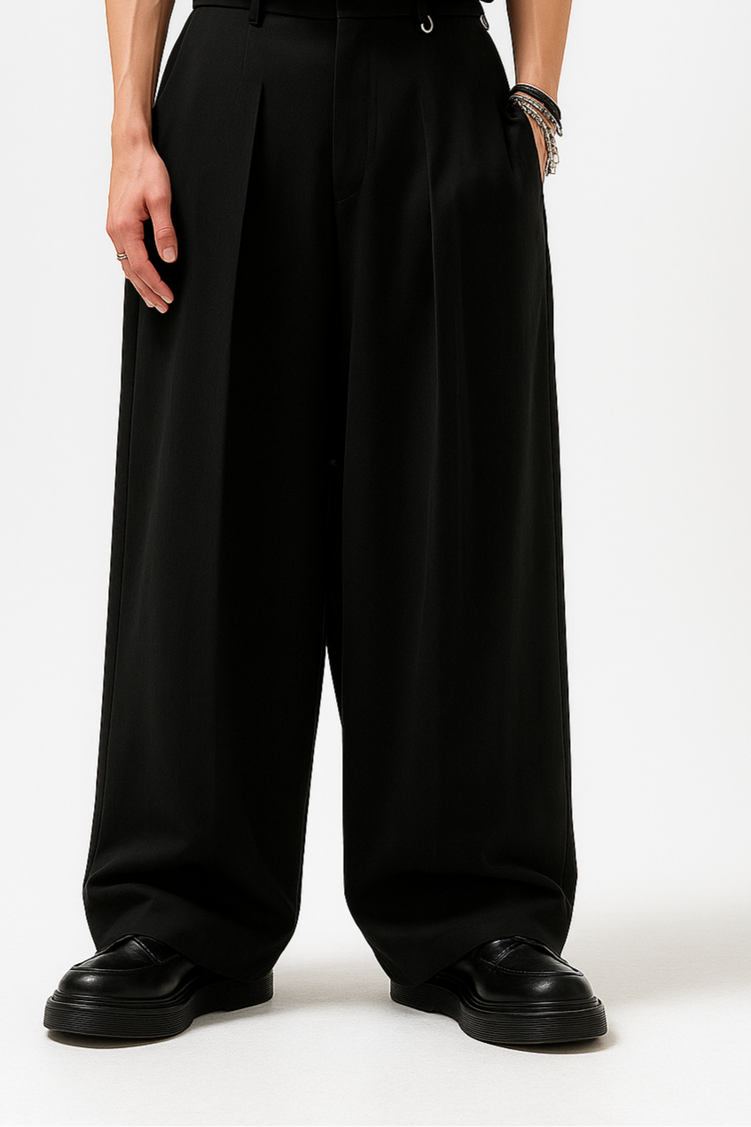 Person wearing a black outfit with wide-leg pants on a white background