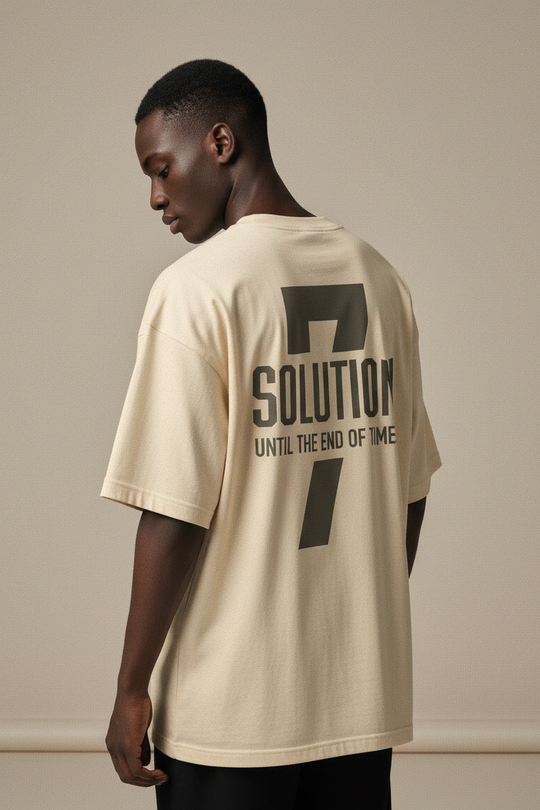 Man wearing a beige t-shirt with text on the back against a plain background