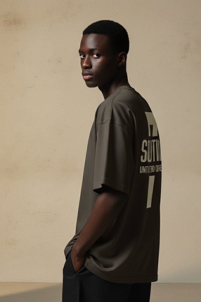 Man wearing a dark green t-shirt with text on the back against a beige background