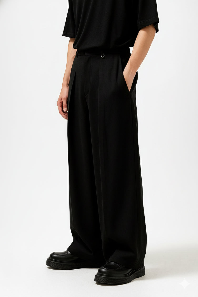 Person wearing a black outfit with wide-leg pants on a white background