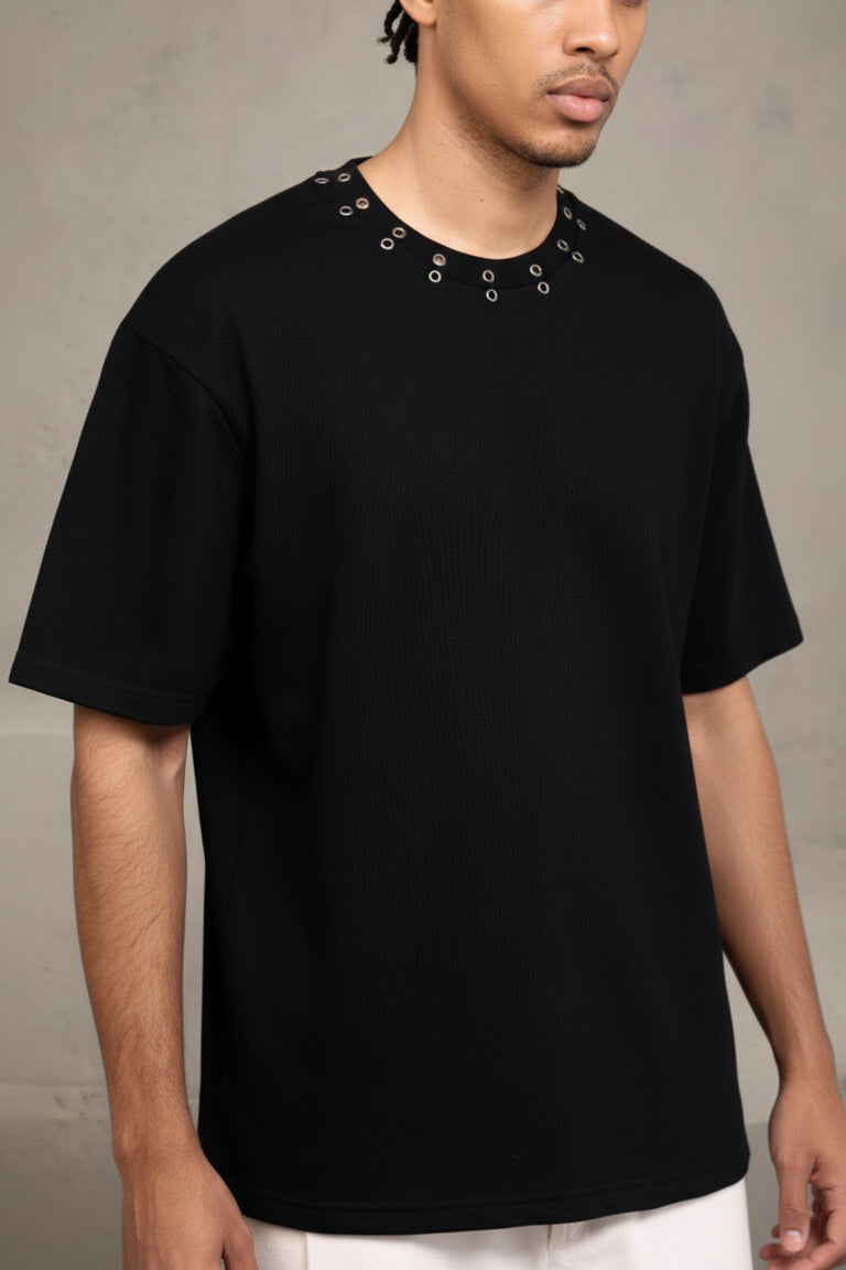 Person wearing a black t-shirt with unique collar design against a neutral background
