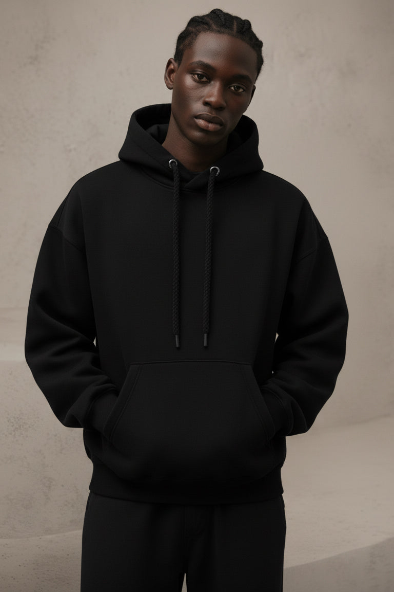 Person wearing a black hoodie against a neutral background