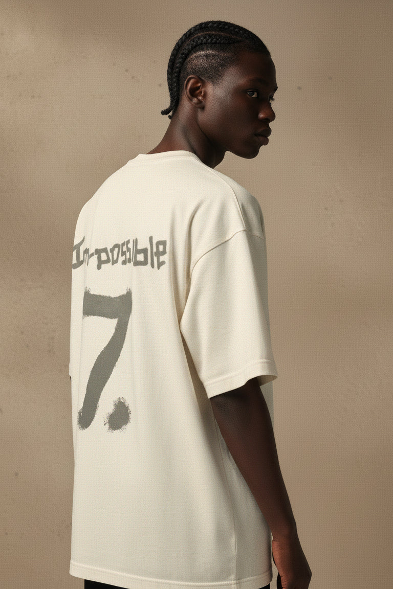 Person wearing a white t-shirt with text and number on a beige background