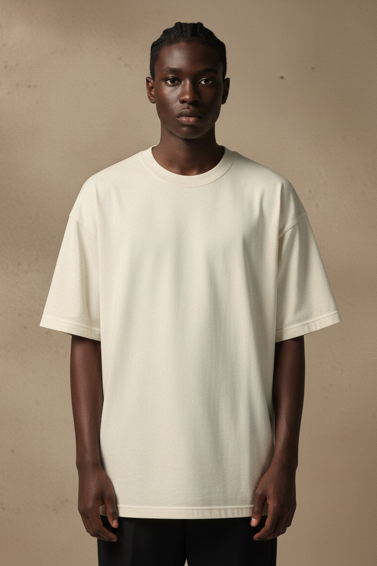 Person wearing a plain beige t-shirt against a beige background