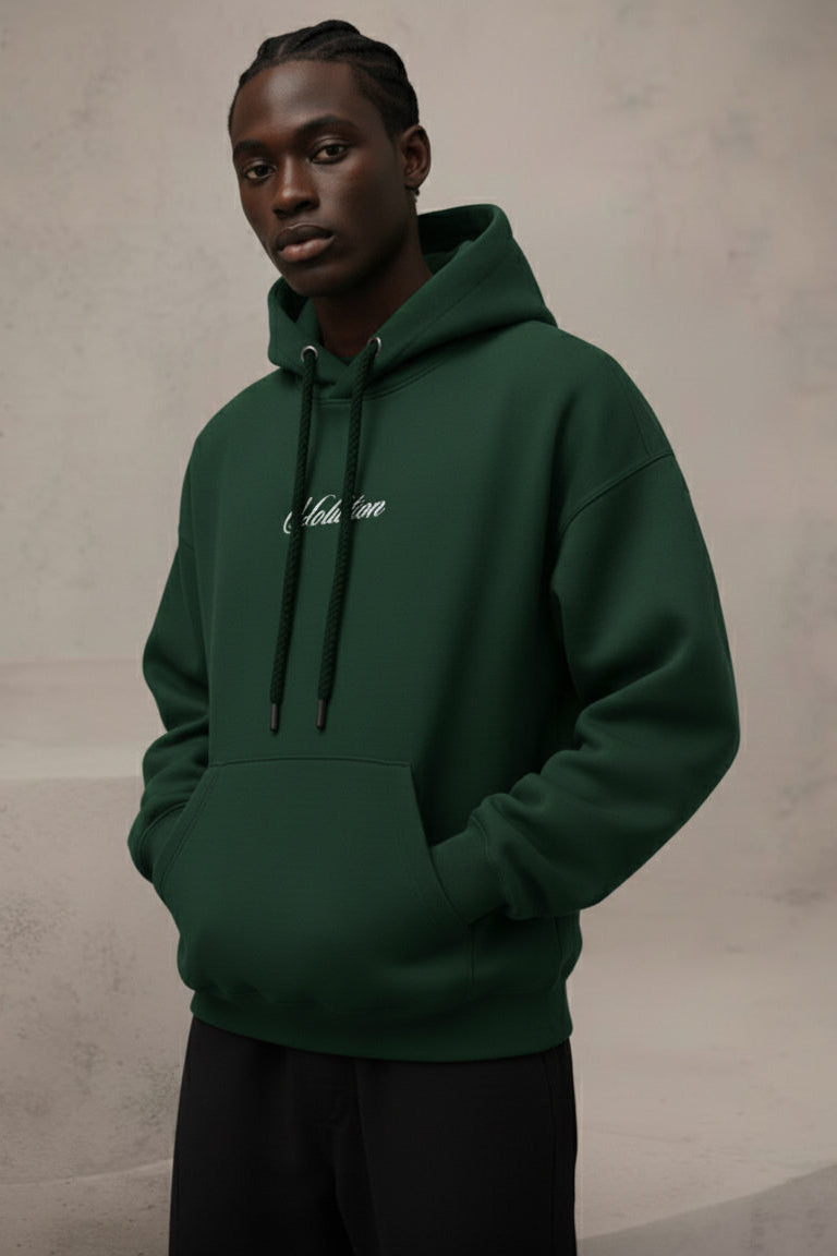 Person wearing a green hoodie with text on a plain background