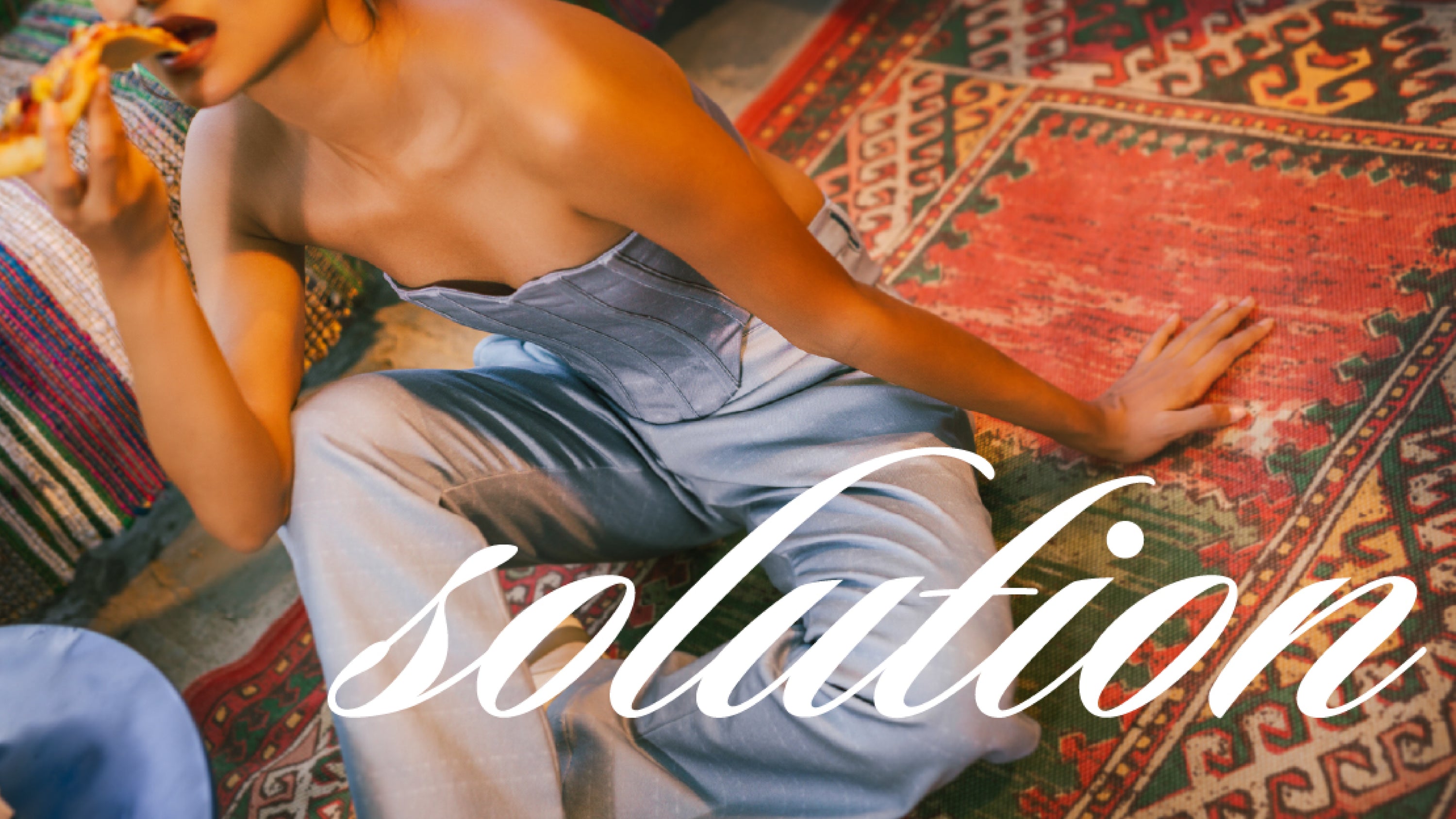 Person sitting on a colorful rug with the word 'solution' overlaid.