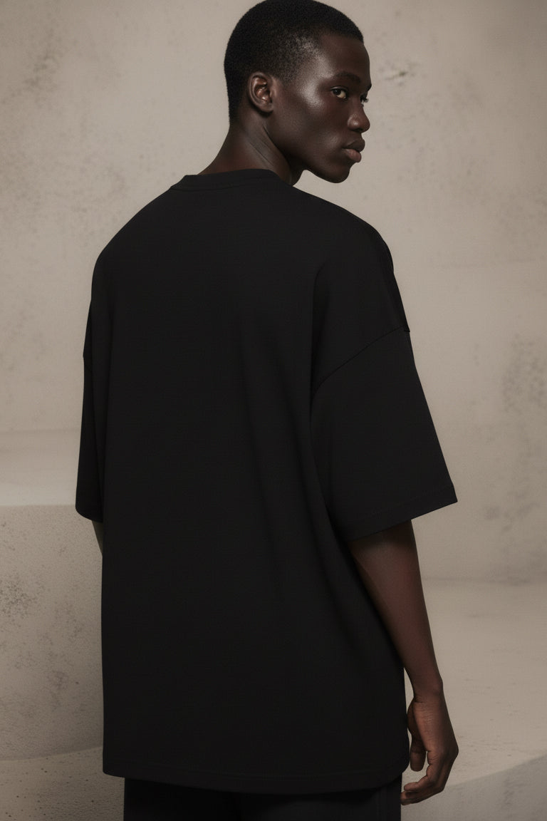 Person wearing a black t-shirt against a plain background