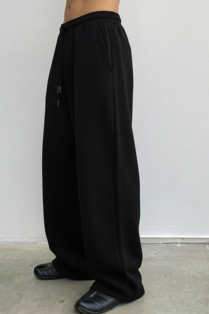 Black wide-leg pants worn by a person against a white background