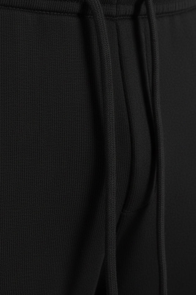 Close-up of black pants with a drawstring