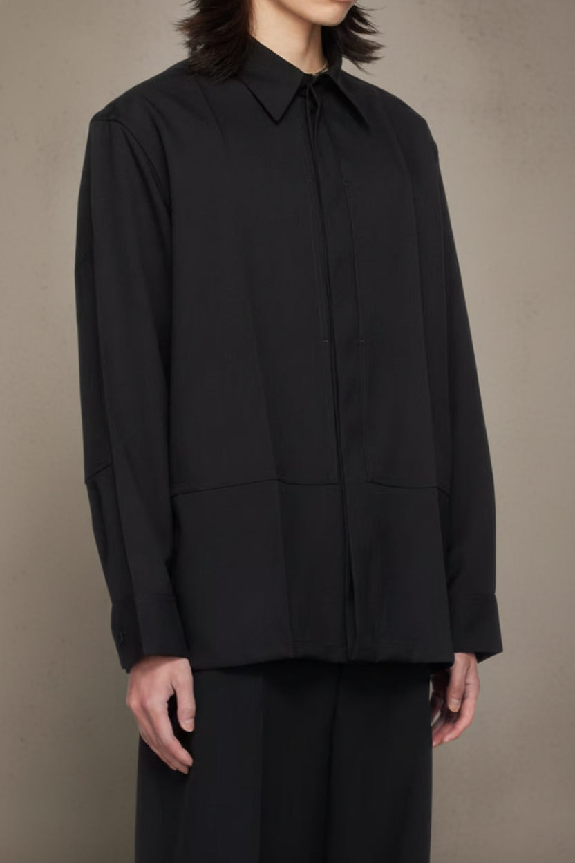 Person wearing a black shirt and pants against a beige background