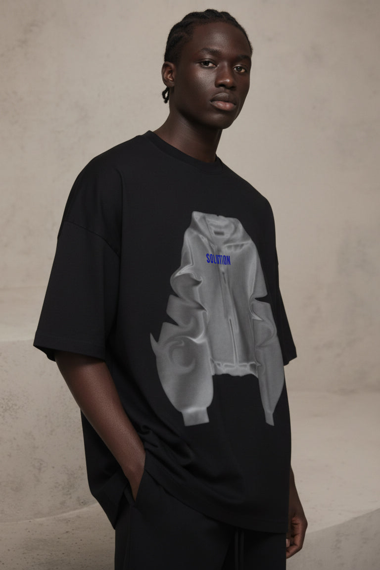 Person wearing a black t-shirt with a graphic design on a beige background