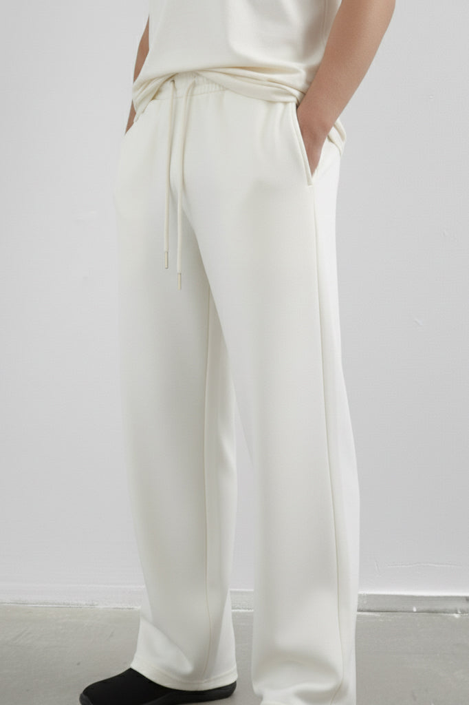 White pants worn by a person on a plain background